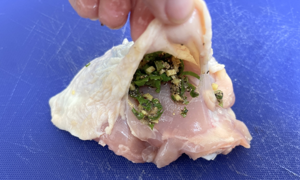 Working with one piece of chicken at a time, slide fingers between the skin and meat being careful not to detach the skin. Place about 1 tablespoon of the rub under the skin