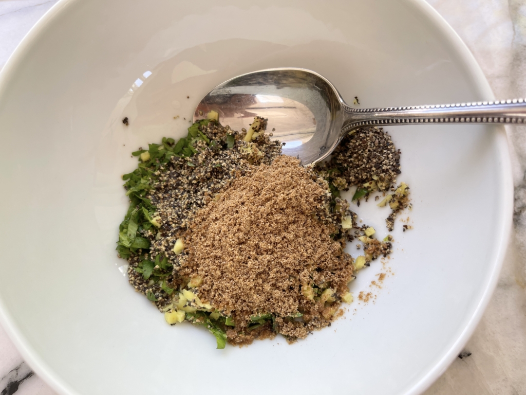 Place garlic, ginger, black pepper, ground coriander, cilantro, lime juice and oil in a medium-sized bowl.