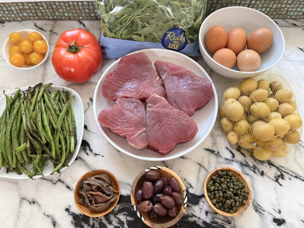ingredients - sushi grade tuna steaks, jammy eggs, yukon gold baby potatoes, haricot verts, kalamata olives, capers, tomatoes (any kind), anchovies and arugula.