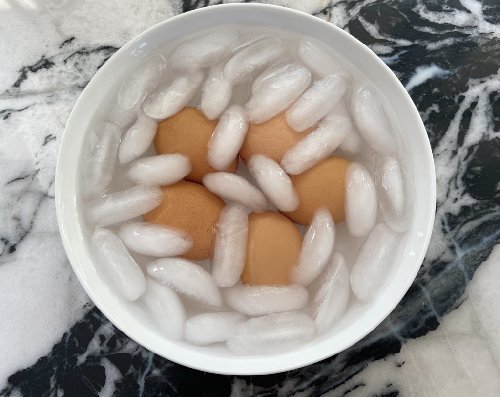 After 7 minutes and 30 seconds (set timer!) transfer the eggs to an ice bath for 3 minutes to stop them for cooking. The ice water bath also will make the eggs easier to peel. Peel the eggs. Store peeled eggs in the refrigerator.