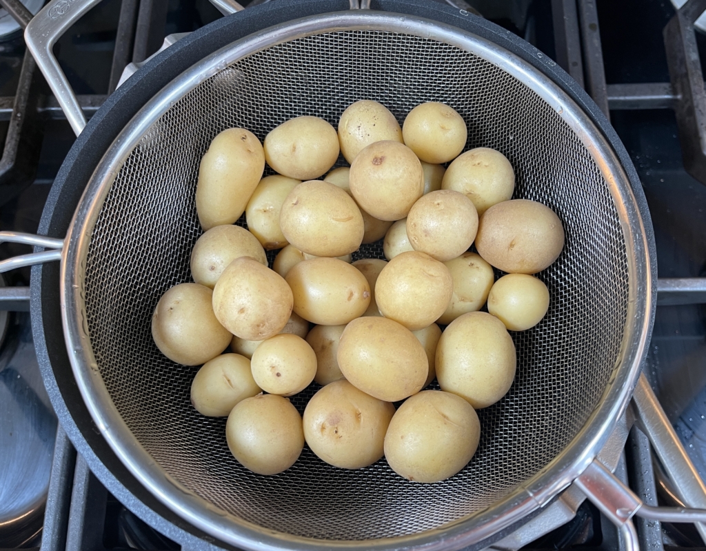 Then place the colander with the potatoes over the empty pot off the heat