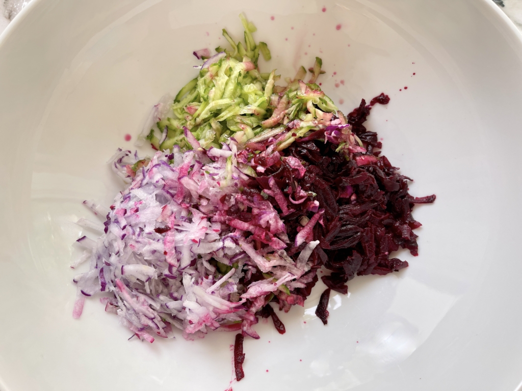 Place grated cucumbers, radishes, and roasted beets in a large bowl