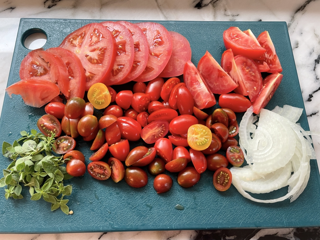 slice the tomatoes into various shapes (rounds, wedges and halves), slice or rough chop the onions, and remove the leaves from the stems on the oregano