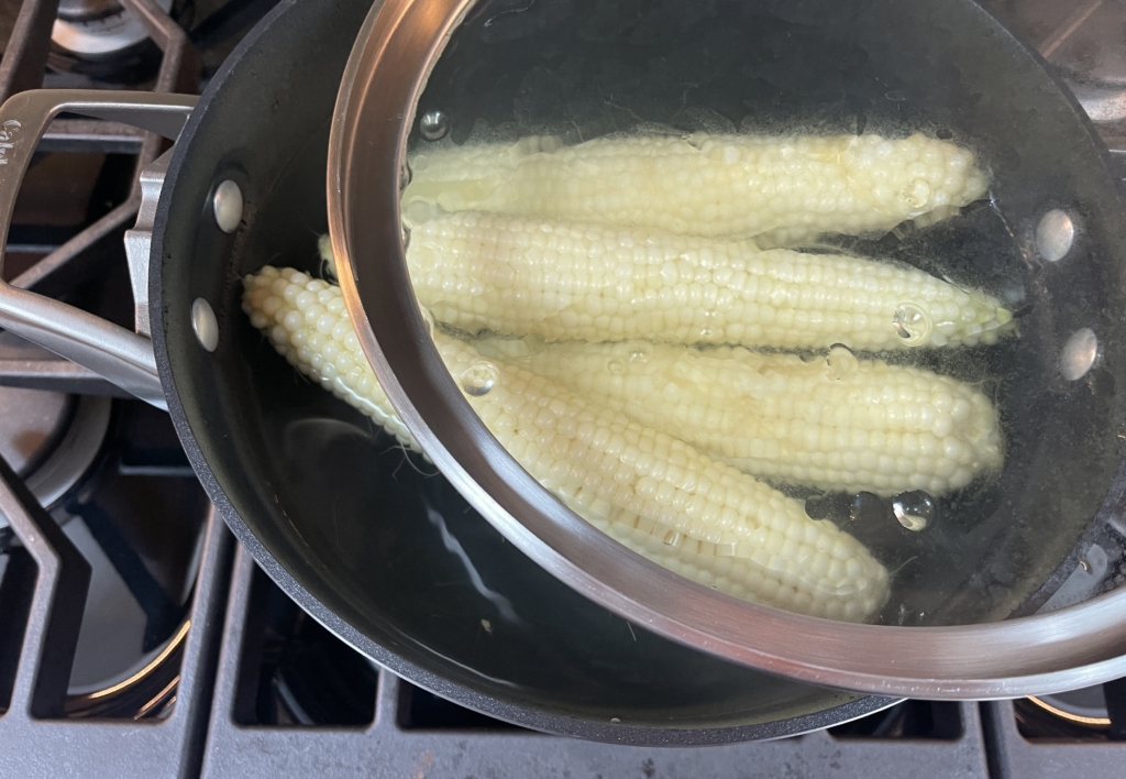 Turn off heat and partially cover with lid to keep the corn warm.