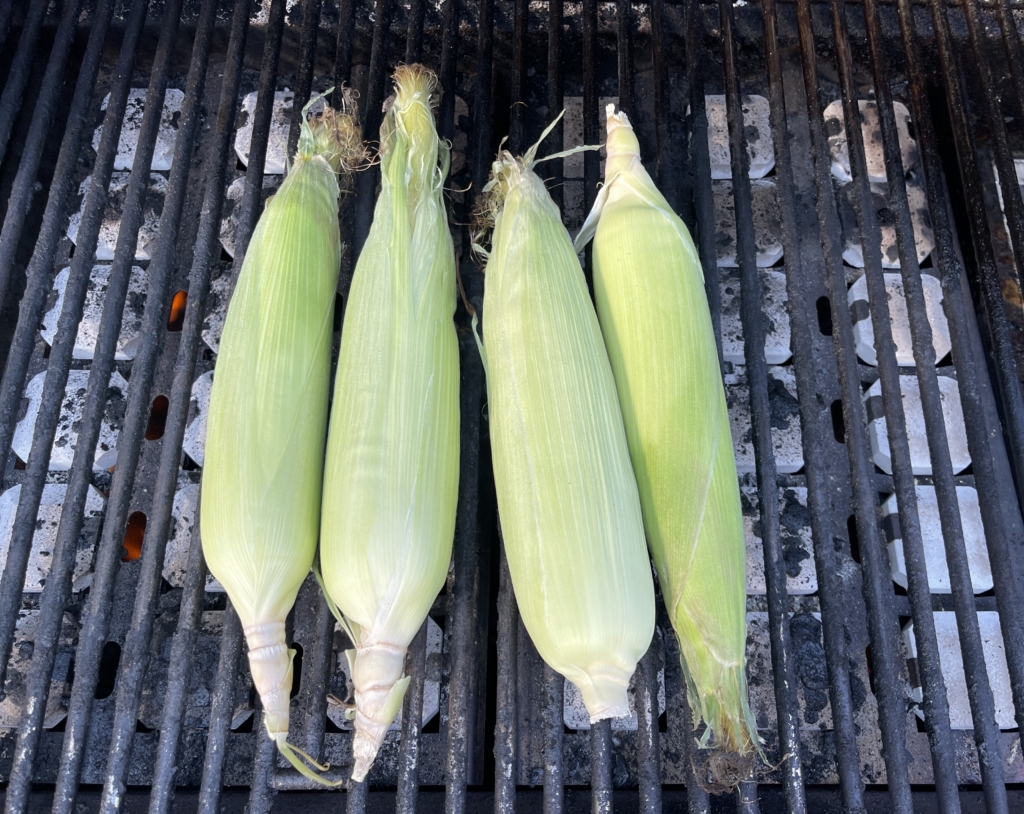 Place unhusked corn on a preheated grill at medium-high heat. Close lid and cook for 8-10 minutes