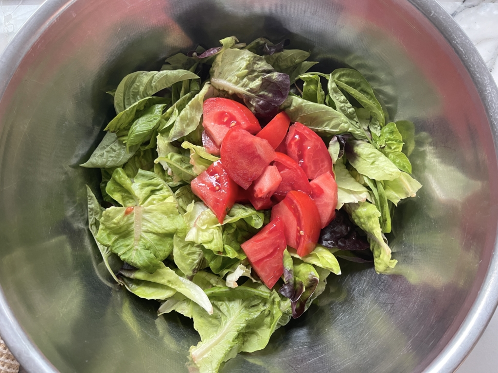 Add lettuce and tomatoes to the dressing and gently toss with tongs until salad is lightly coated.