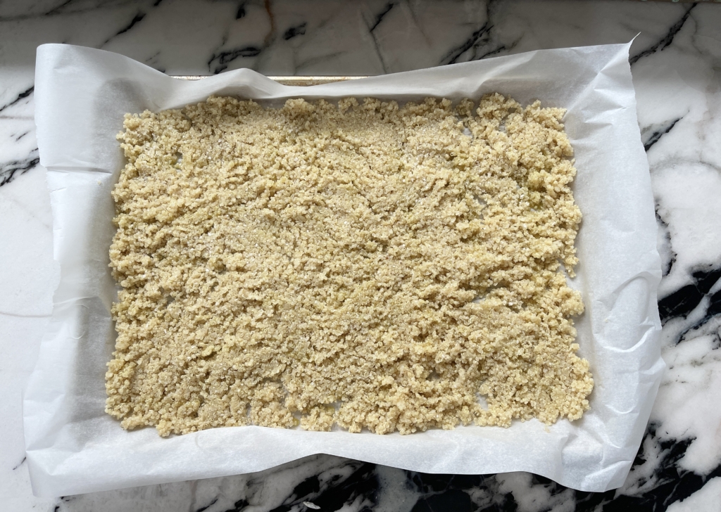 Place cooked quinoa on a parchment-paper lined baking sheet. Drizzle 2 tablespoons of oil, kosher salt and pepper, and gently combine, either with your hands or a spatula