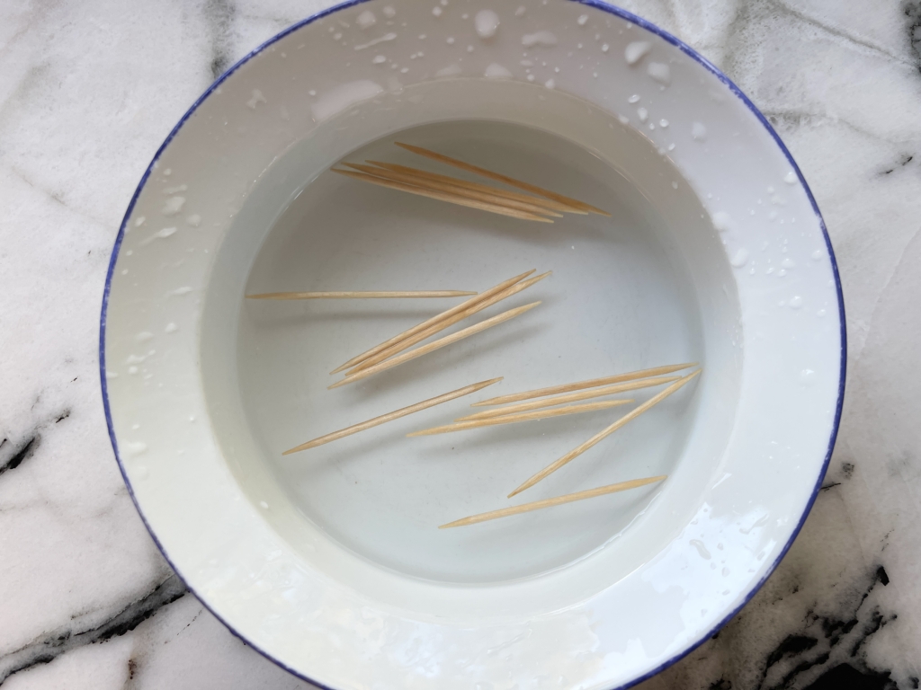 Place toothpicks in a bowl of cold water to prevent them from burning while the dates cook