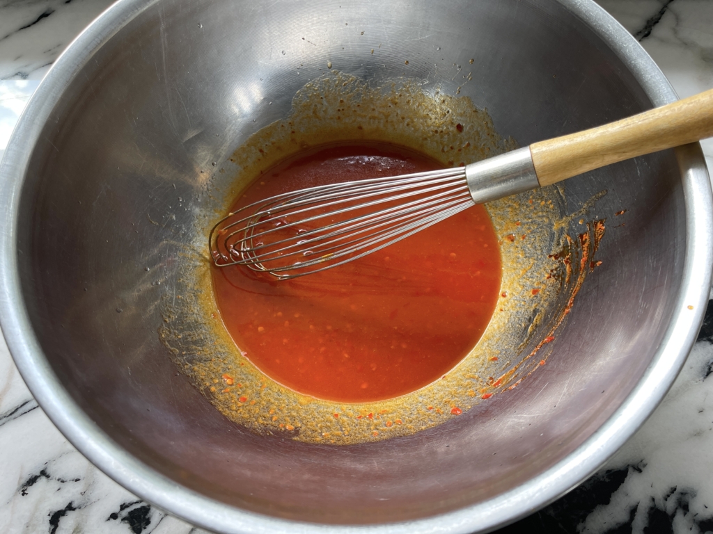 Scrape honey butter into a large bowl and add harissa paste, lemon juice, and kosher salt, and whisk until smooth and emulsified. 