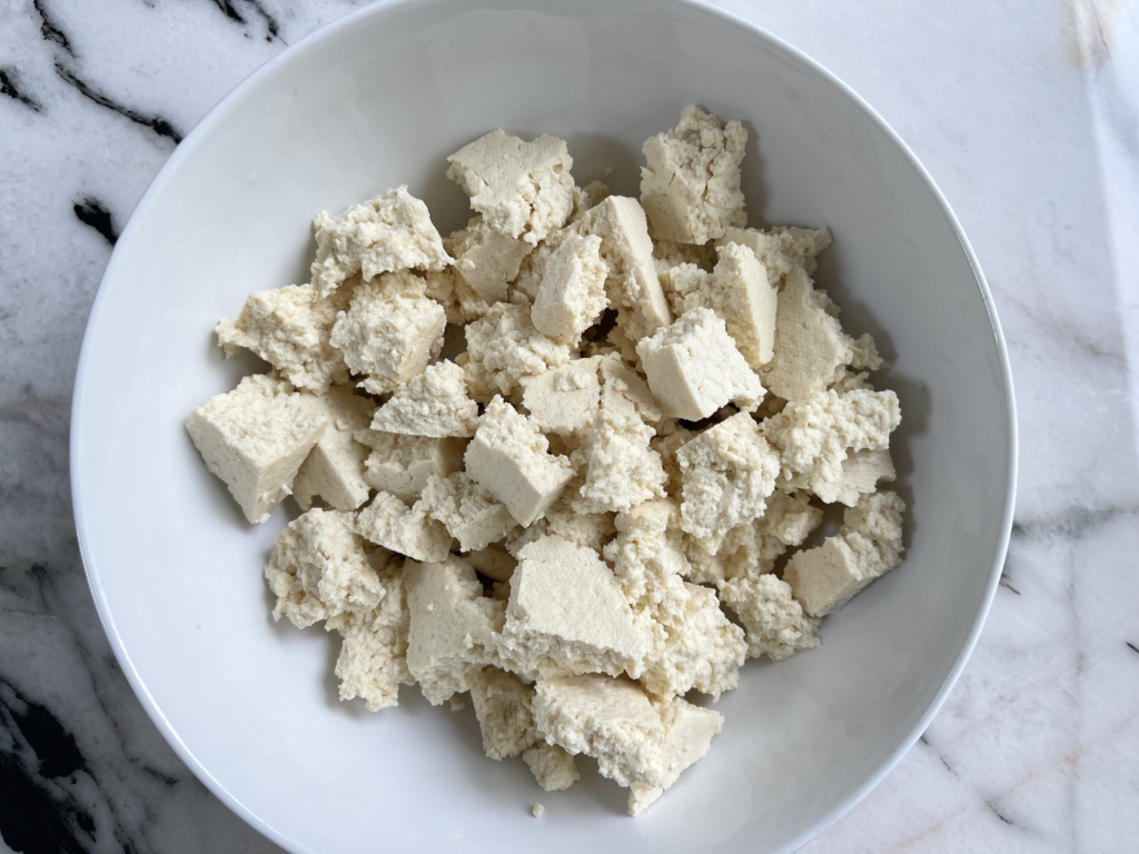 Using your hands, tear tofu into small-ish uneven pieces and place tofu into a medium-sized bowl.