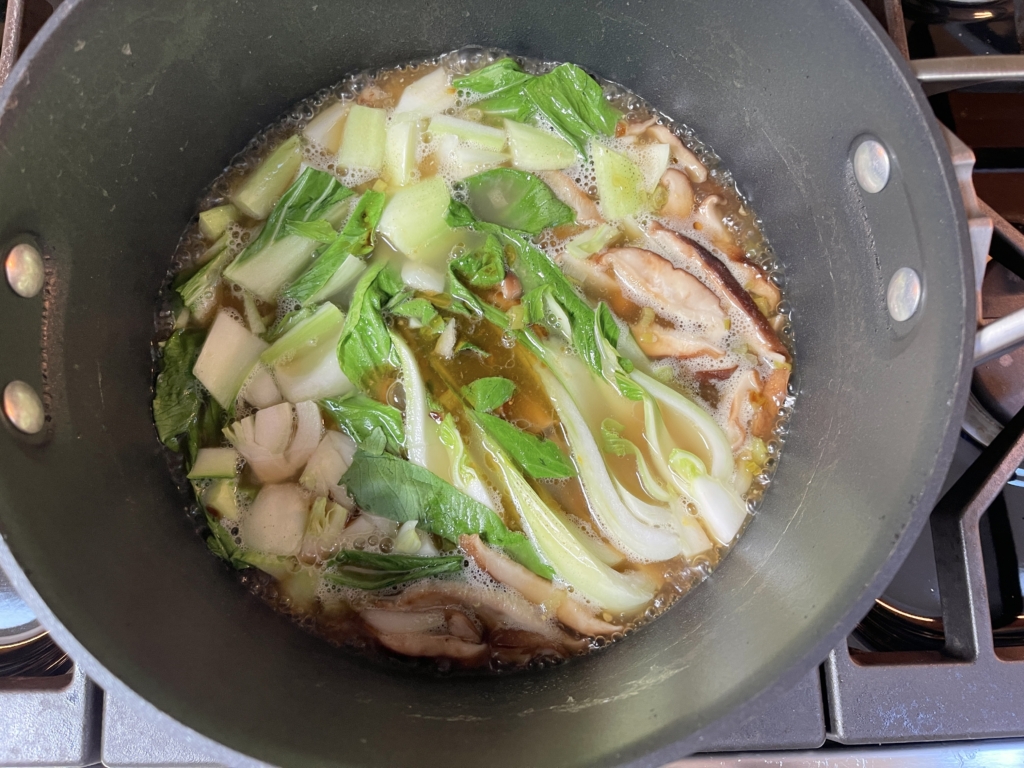 Add bok choy, gluten free soy sauce, sesame oil and additional salt to the broth. Once all ingredients are added, turn down the heat and let simmer for 2-3 minutes.