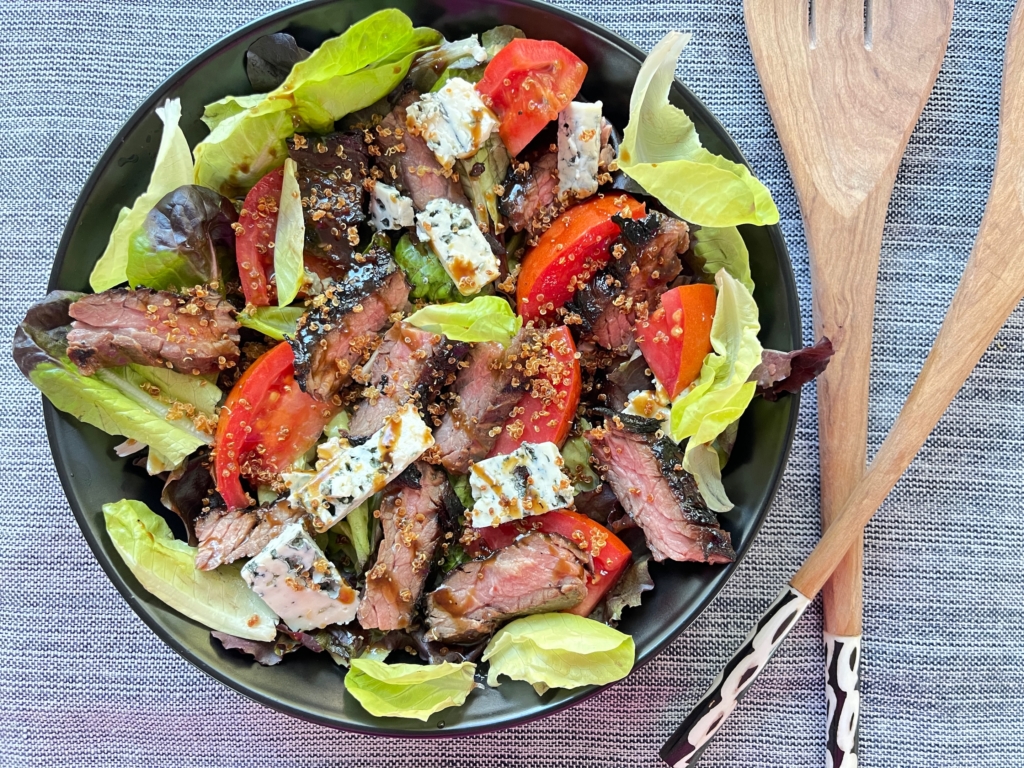 Place salad onto a platter or divide among plates. Arrange steak and blue cheese on top of the salad, sprinkle a handful of Quinoa Crunchies on top (optional), and season with black pepper. If needed, spoon additional dressing over the salad and serve. 