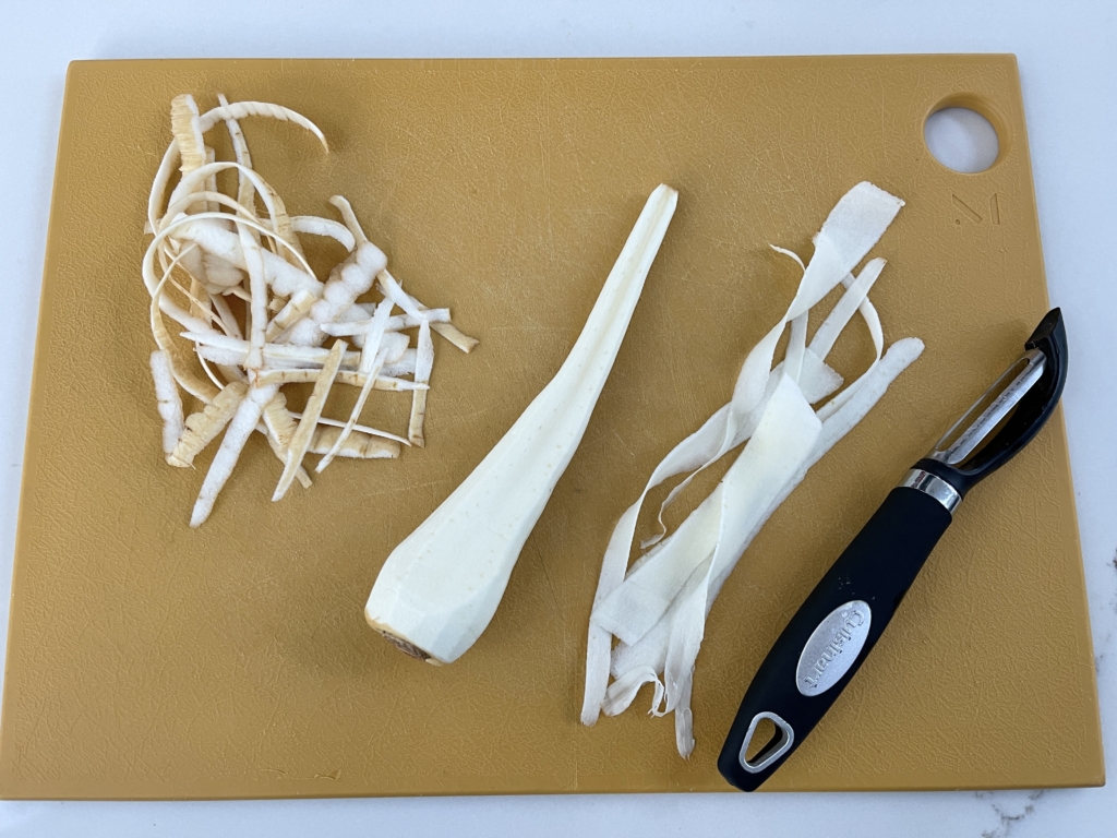 Remove the outer layer of the parsnip with a peeler. Then lay parsnip flat on a cutting board and using the peeler, go from the root to the tip to create the ribbons.