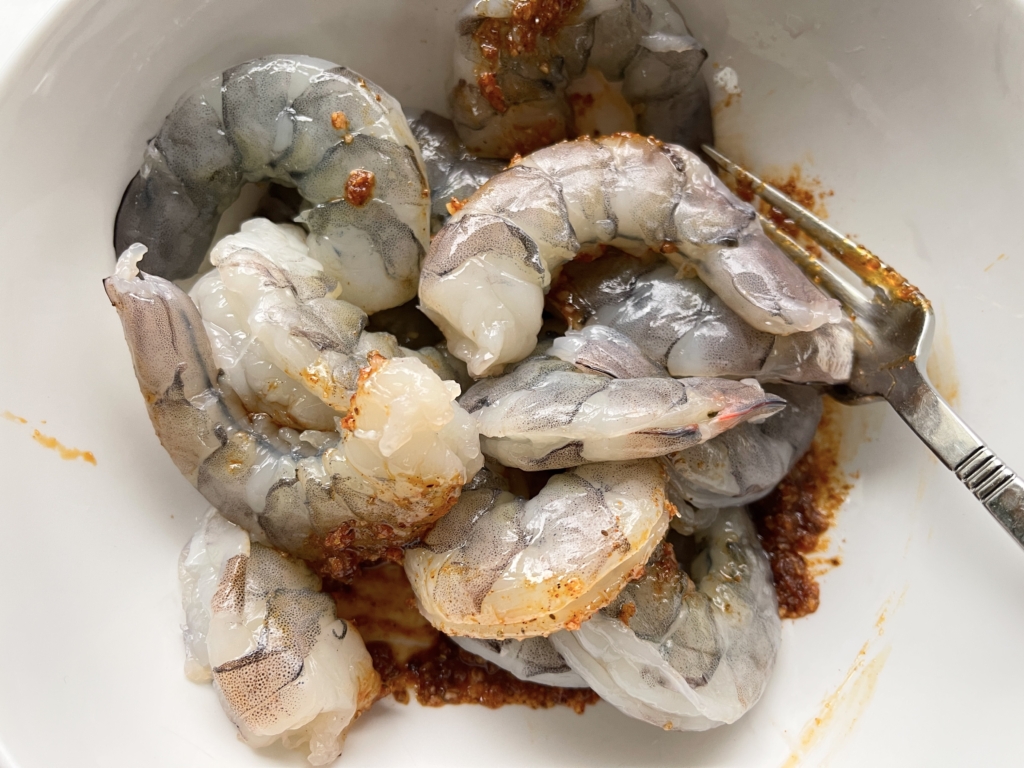 Place shrimp to a medium bowl. Add 1 tablespoon olive oil, two cloves of finely grated or pressed garlic, 1½ teaspoon Old Bay, and ¾ teaspoon kosher salt.