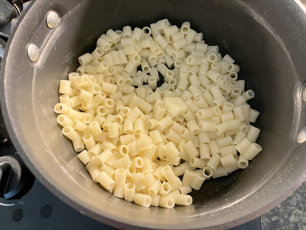 Return pasta to the pot and melt in the butter using a large spoon to combine.