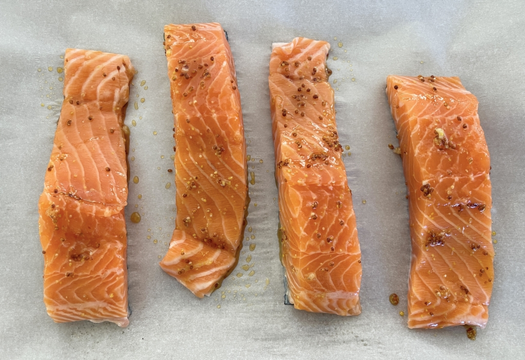 Place salmon fillets on a baking sheet lined with parchment paper. Spoon 1-2 teaspoons of mustard mixture onto each fillet and lightly coat the fillets. 