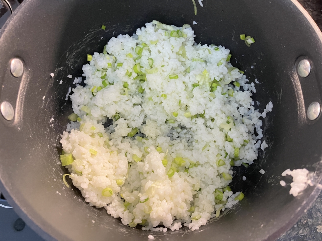 While the chicken is marinating, toss the cooked rice with the remaining 1½ teaspoons salt, scallion whites and 3 tablespoons of extra-virgin olive oil. 