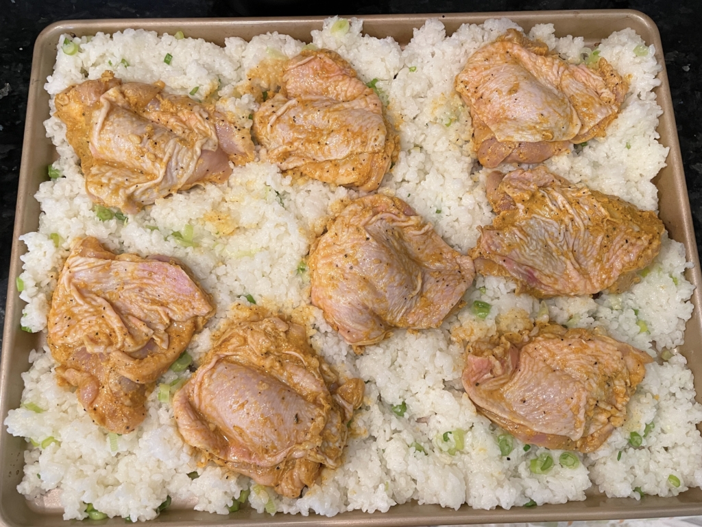 Use a large spoon to carefully spread the rice out on the hot sheet pan, then make divots in the rice for the chicken, making sure the sheet pan is exposed. Place chicken, skin side up, in the divots touching the pan. Drizzle the rice and chicken with a little more extra-virgin olive oil.