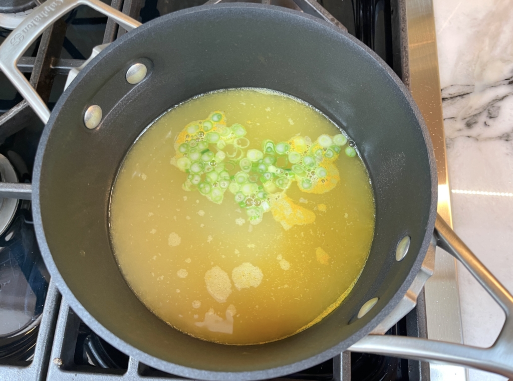 Add the chicken broth to a medium-sized pot and season with white pepper, turmeric powder, kosher salt and the white parts of the scallions. Bring broth to a simmer over medium high heat.