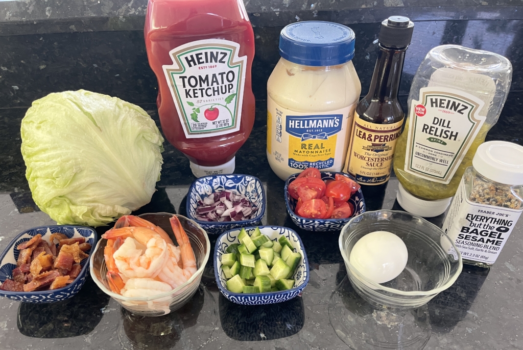 ingredients - mayonnaise, ketchup, relish, worcestershire, red wine vinegar (not photographed), iceberg lettuce, cooked shrimp, cherry tomatoes, cucumbers, hard boiled eggs, bacon, red onion, and Trader Joe's Everything But The Bagel Sesame Mixture.