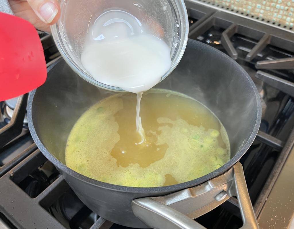 Once the soup reaches a simmer, lower the heat to medium and slowly pour the cornstarch slurry into the pot while simultaneously stirring the broth. Stir until the soup thickens 1-2 minutes.