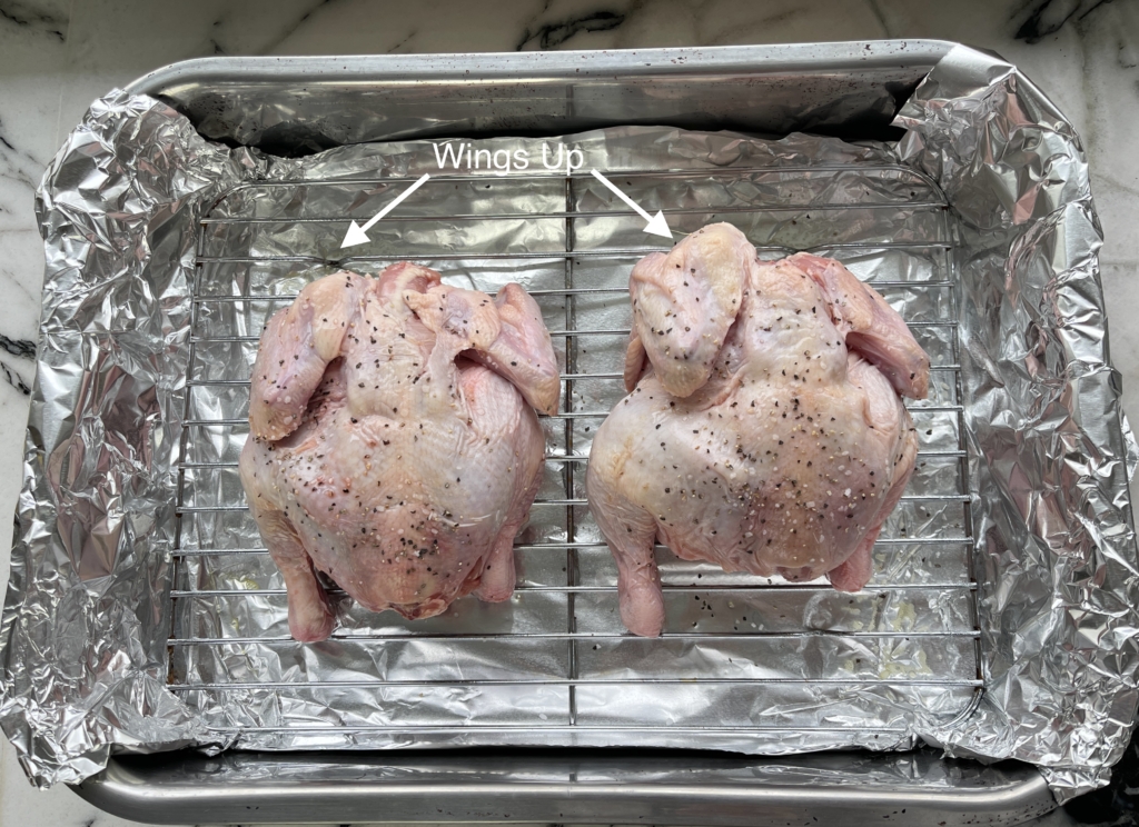 Line a roasting pan with foil and then place a roasting rack inside of the pan and spray with oil. Both of these suggestions allow for easier pan and rack clean up. Place hens on the rack breast-side down. You’ll know you’ve done it correctly if the wings are facing up.