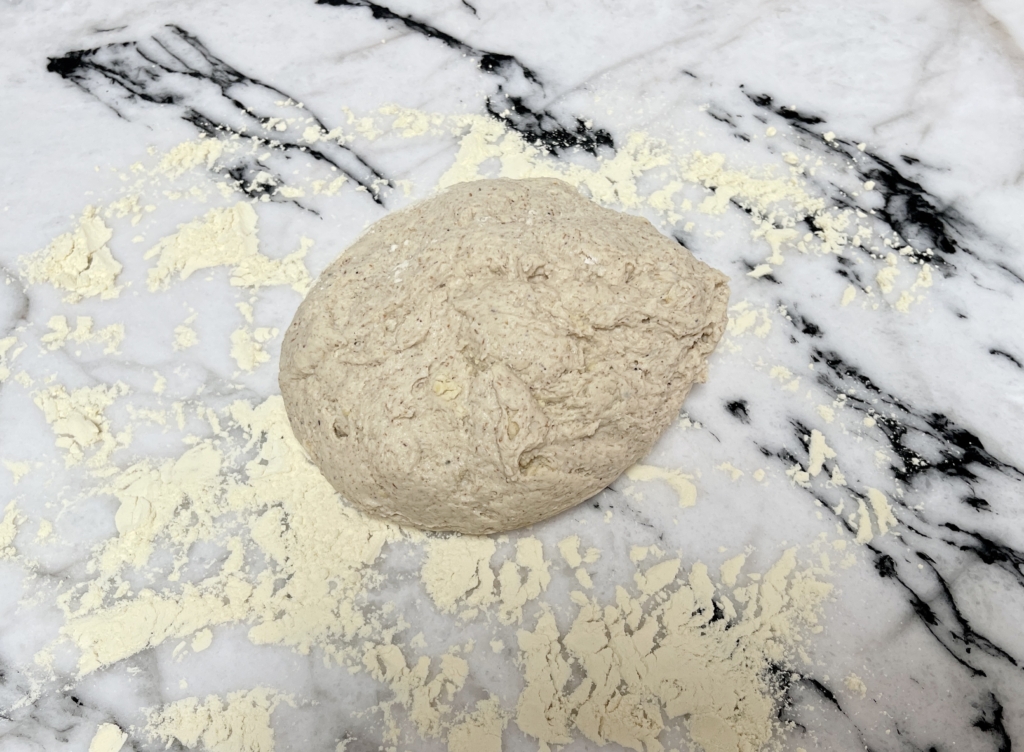 Place the dough onto a lightly floured surface and give it a gentle knead, shaping it into a ball.
