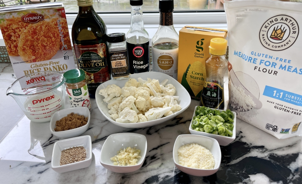 ingredients - cauliflower, gluten free soy sauce, gluten free flour, milk, parmesan, garlic powder, paprika, gluten free panko crumbs, sesame oil, olive oil, scallions, minced garlic, ginger, dark brown sugar, rice vinegar, cornstarch mixed with cold water which is also know as Cornstarch Slurry, and sesame seeds