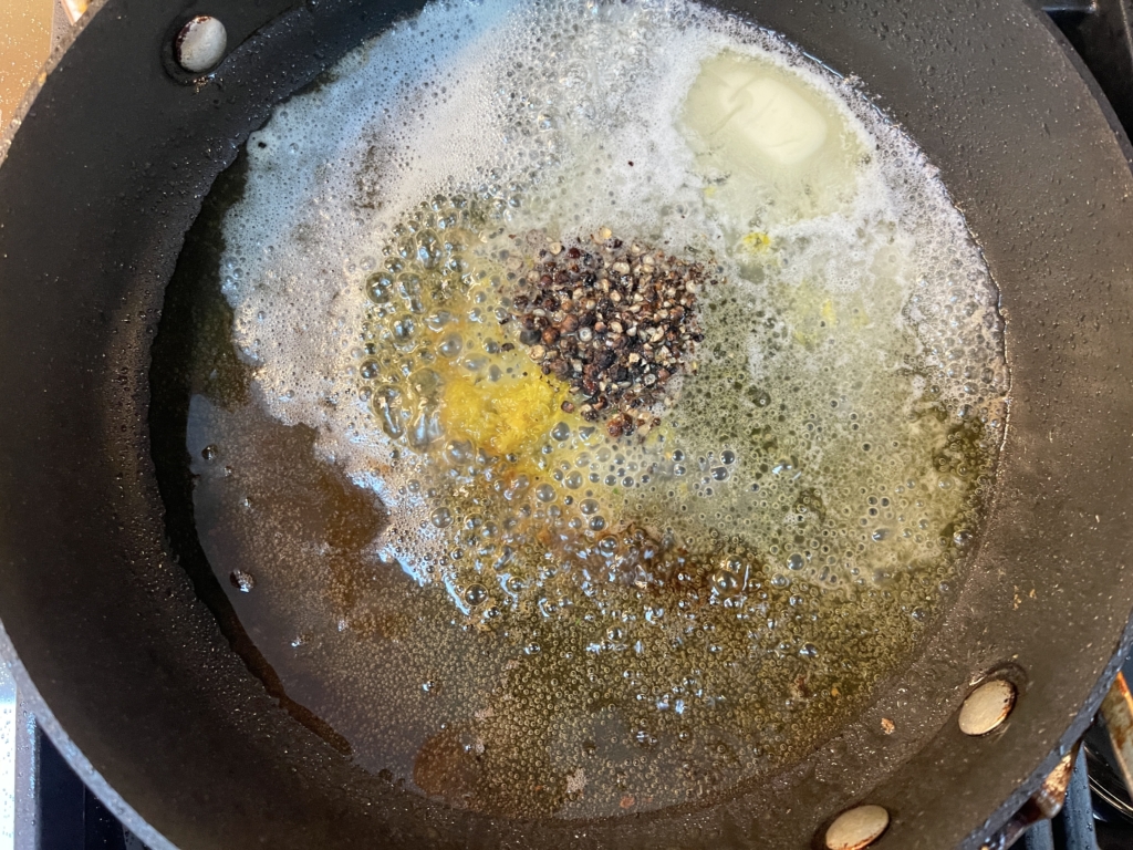 Using the same pan, add the butter, remaining 3 tablespoons of olive oil, and the coarsely crushed peppercorns and cook over medium-low heat.