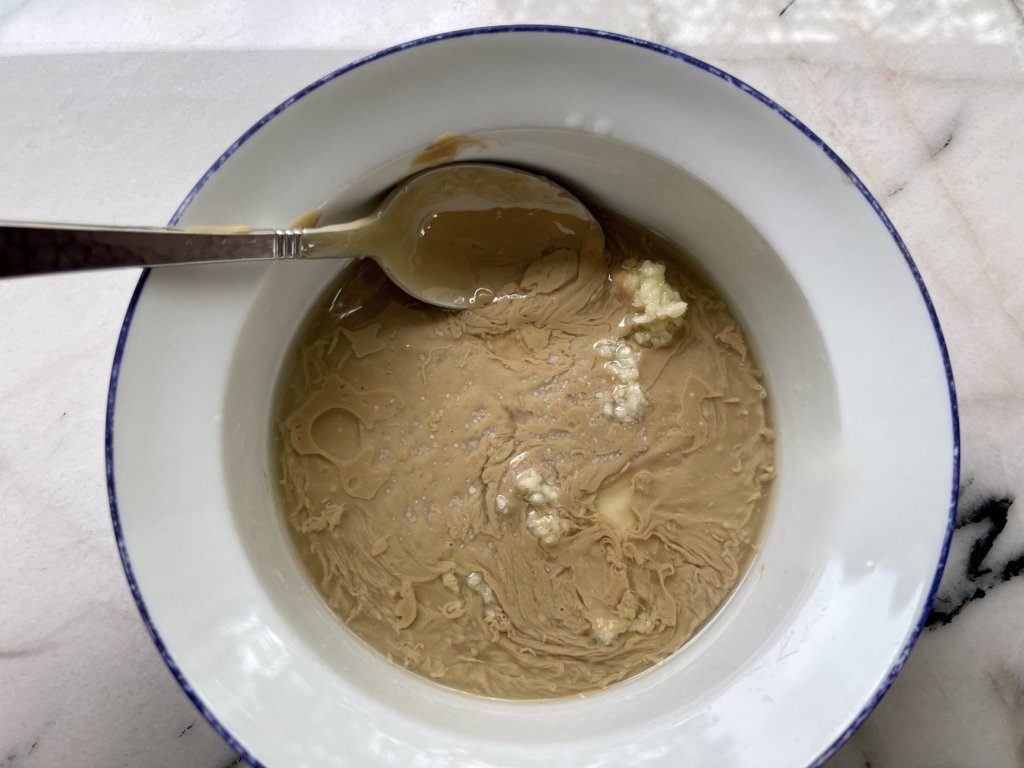 Place tahini, garlic, lemon juice, and pinch of salt in a medium-sized bowl.