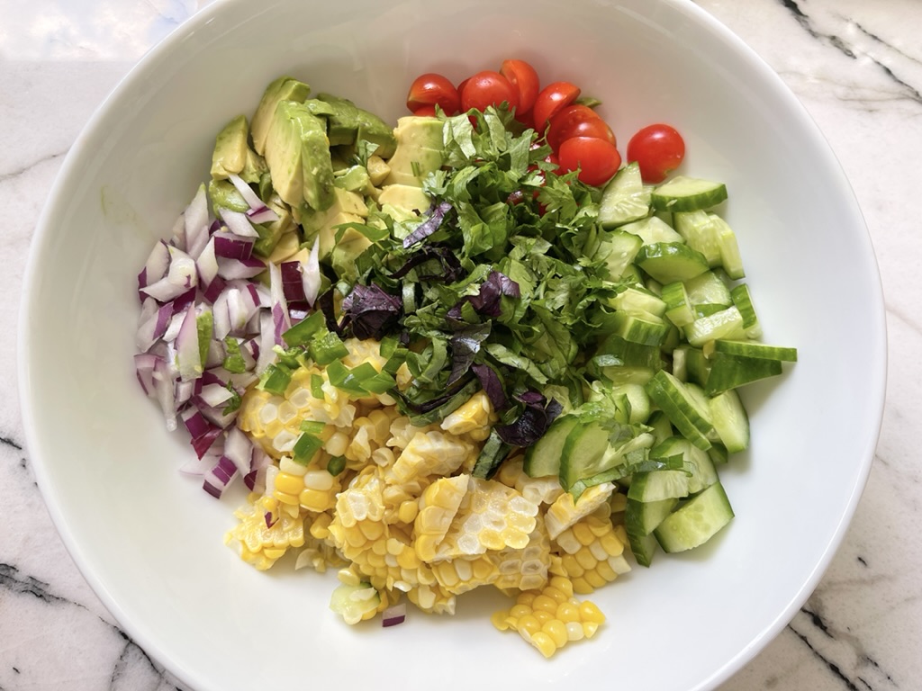 Place the corn, avocado, tomatoes, cucumber, onion, jalapeño (if using) and fresh herbs in a medium sized bowl. Season with kosher salt and pepper.