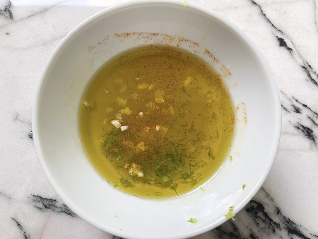 Combine the lime zest, juice, olive oil, honey, garlic, cayenne (if using) in a medium sized bowl. Season with kosher salt and freshly ground pepper.