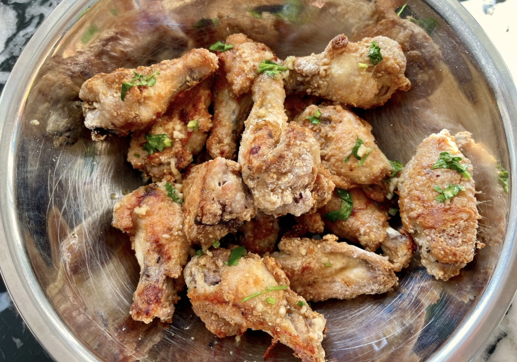 Transfer wings to a medium sized bowl and toss with 2 tablespoons of the sauce and cilantro onto the wings. Don’t over sauce because you still want to eat crispy wings. 