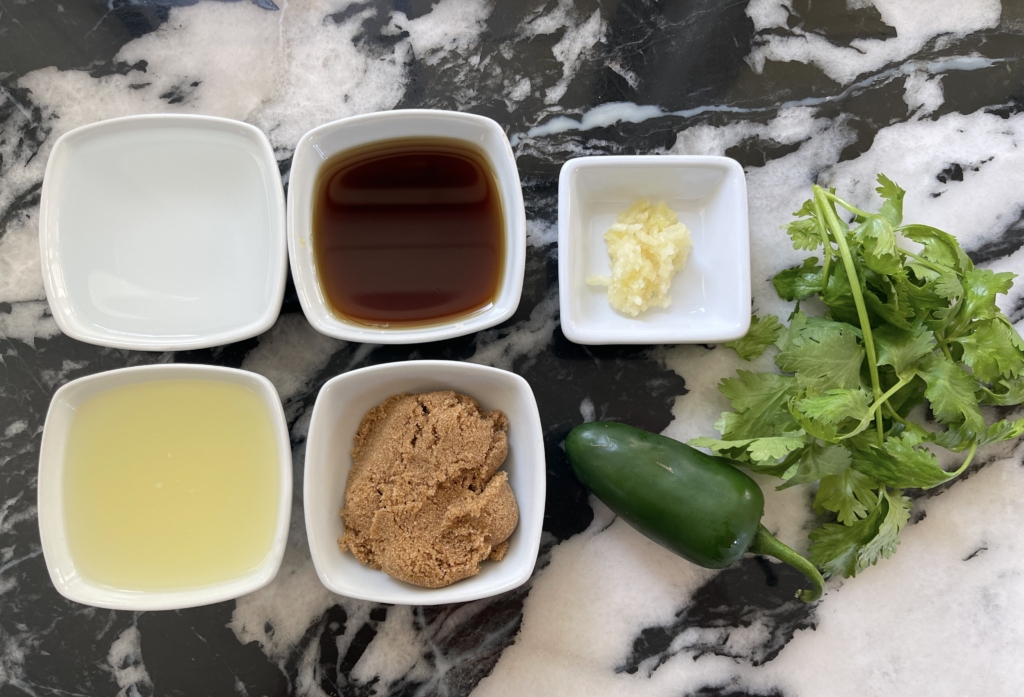 sauce ingredients - dark brown sugar, garlic, lime juice, fish sauce, water, jalapeno, and cilantro