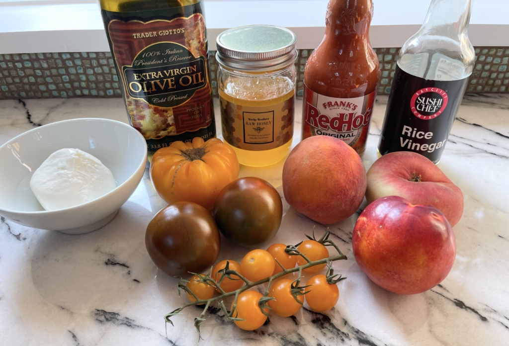 ingredients - peaches, tomatoes, burrata, olive oil, honey, Frank's hot sauce and unseasoned rice vinegar.