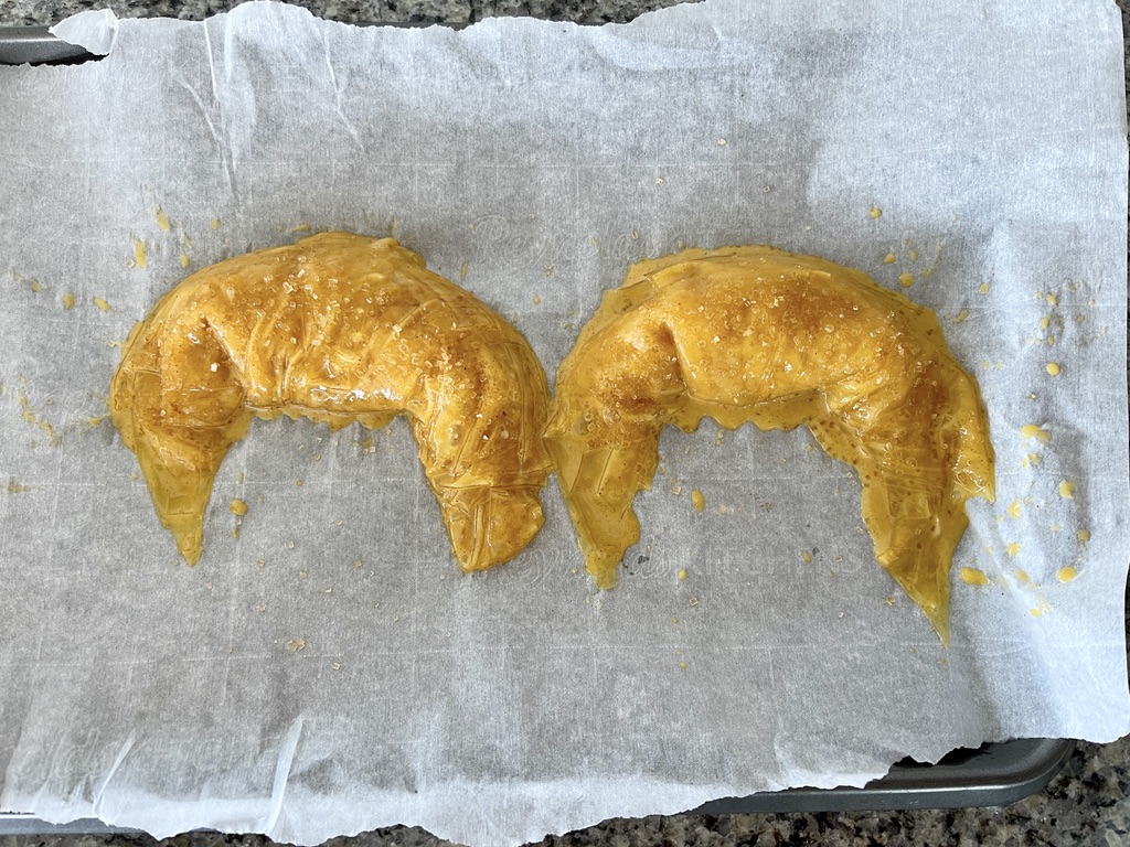 Then bring each end forward to form a croissant shape and sprinkle with sugar in the raw.