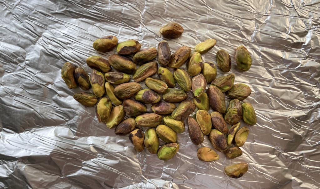 Preheat oven to 350°. Place pistachios on a rimmed baking sheet lined with foil or parchment paper,