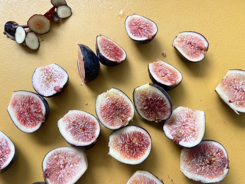 Wash, dry, and trim figs. Then cut each fig in half.