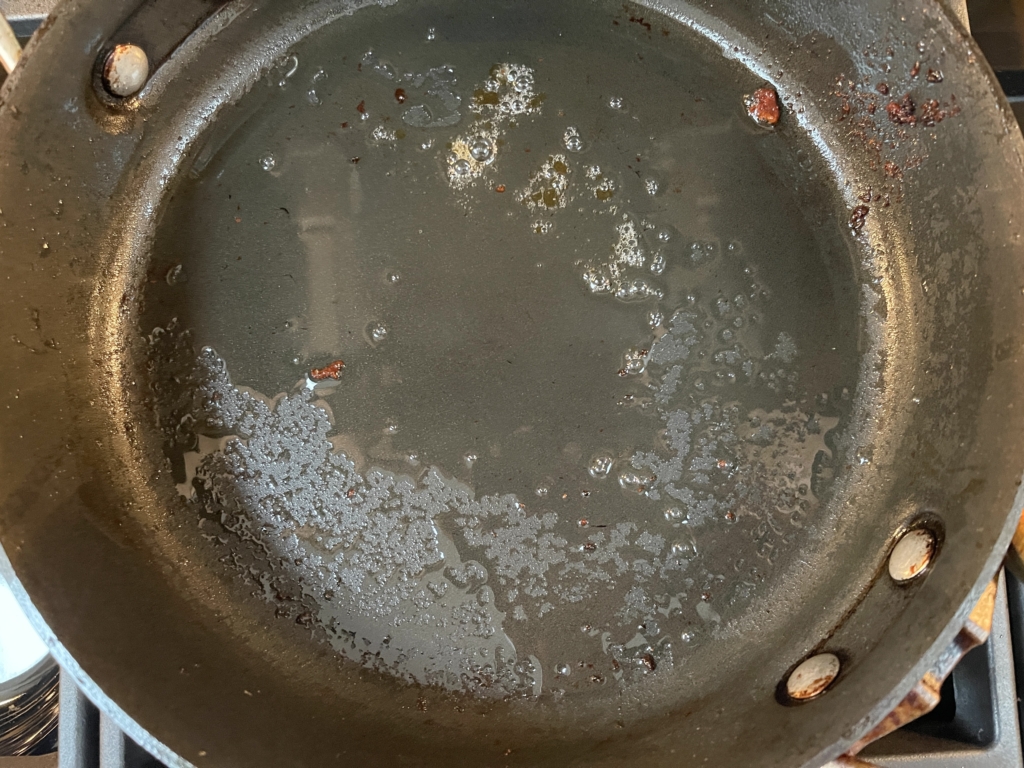 Place pan back onto the stove with 2 tablespoons of the bacon fat (or oil).