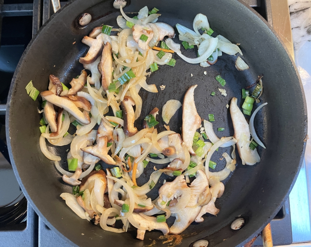 Add 1 tablespoon more neutral oil to the pan and cook the onions, mushrooms, garlic and scallions until softened about 5 minutes. 