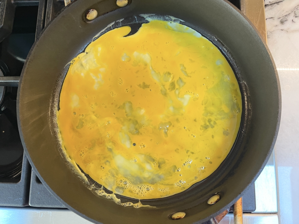 Heat a large nonstick pan with 2 teaspoons oil. Pour the eggs into the pan and swirl the eggs so they spread evenly and thinly. Cook for 1 minute a