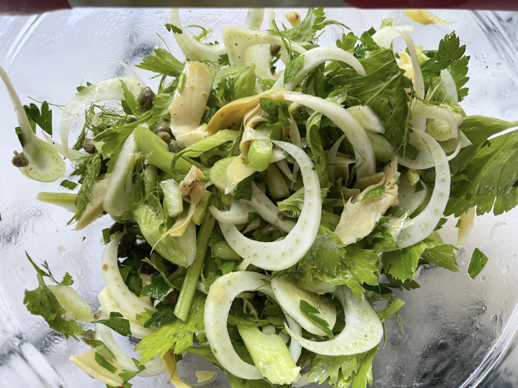 Place celery and leafy tops, fennel and most of fronds (leave some for final garnishing), half of the parmesan, capers, artichokes, and parsley in a large bowl.