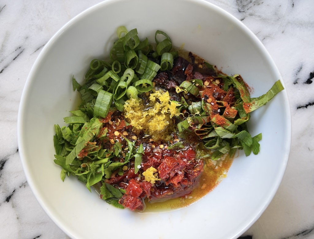 Place olive oil, balsamic vinegar, sun dried tomatoes, olives, garlic, parsley, basil, scallions, lemon zest, smoked paprika, hot pepper flakes and kosher salt in a medium sized bowl.