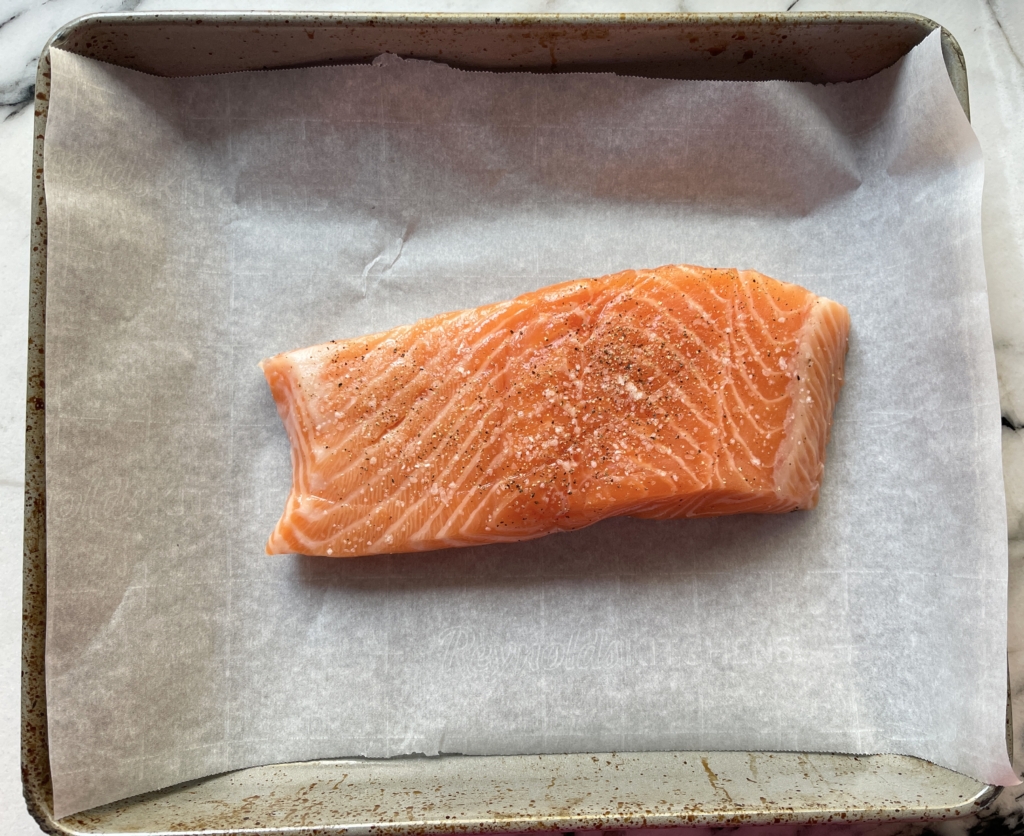 Preheat oven to 400 degrees on Bake setting. Line a baking sheet with parchment or foil. Then add salmon, skin side down to the baking sheet. Season salmon with kosher salt and freshly ground pepper.