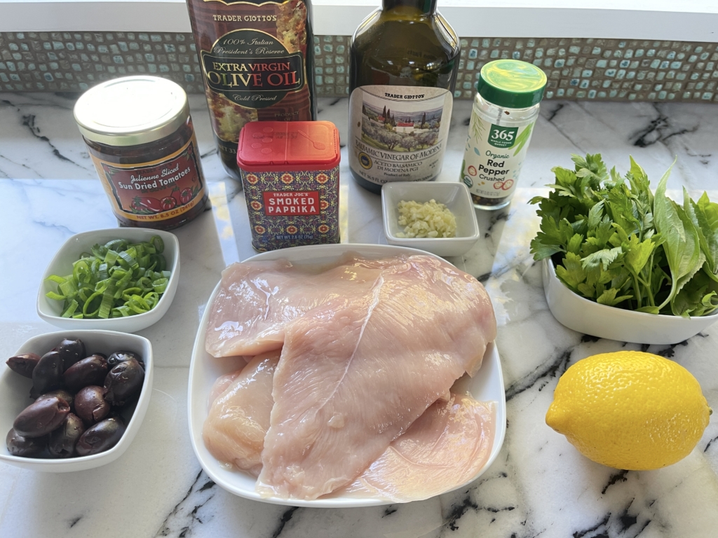 organize the ingredients - boneless, skinless chicken breasts, sun dried tomatoes in oil, kalamata olives, extra virgin olive oil, balsamic vinegar, garlic, parsley, basil, scallions, lemon zest, smoked paprika, hot pepper flakes and  kosher salt.