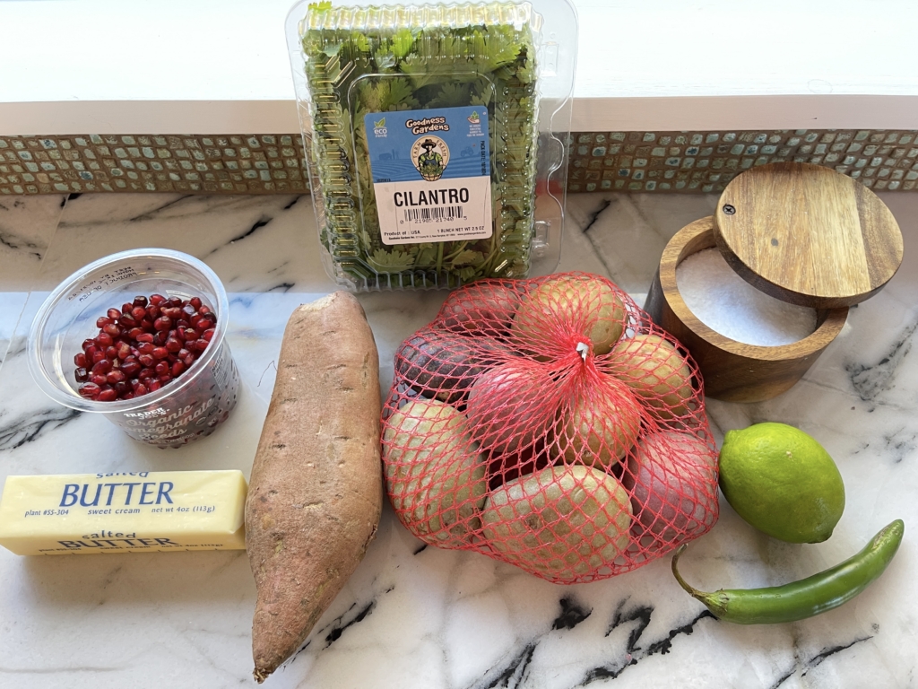 ingredients - multi colored potatoes, cilantro, butter, lime zest, chile peppers, kosher salt and pomegranate seeds.