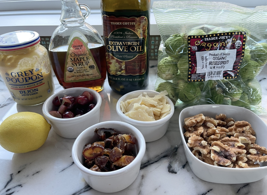 ingredients - brussels sprouts, grapes, walnuts, dates, parmesan, maple syrup, olive oil, lemon, and dijon mustard.