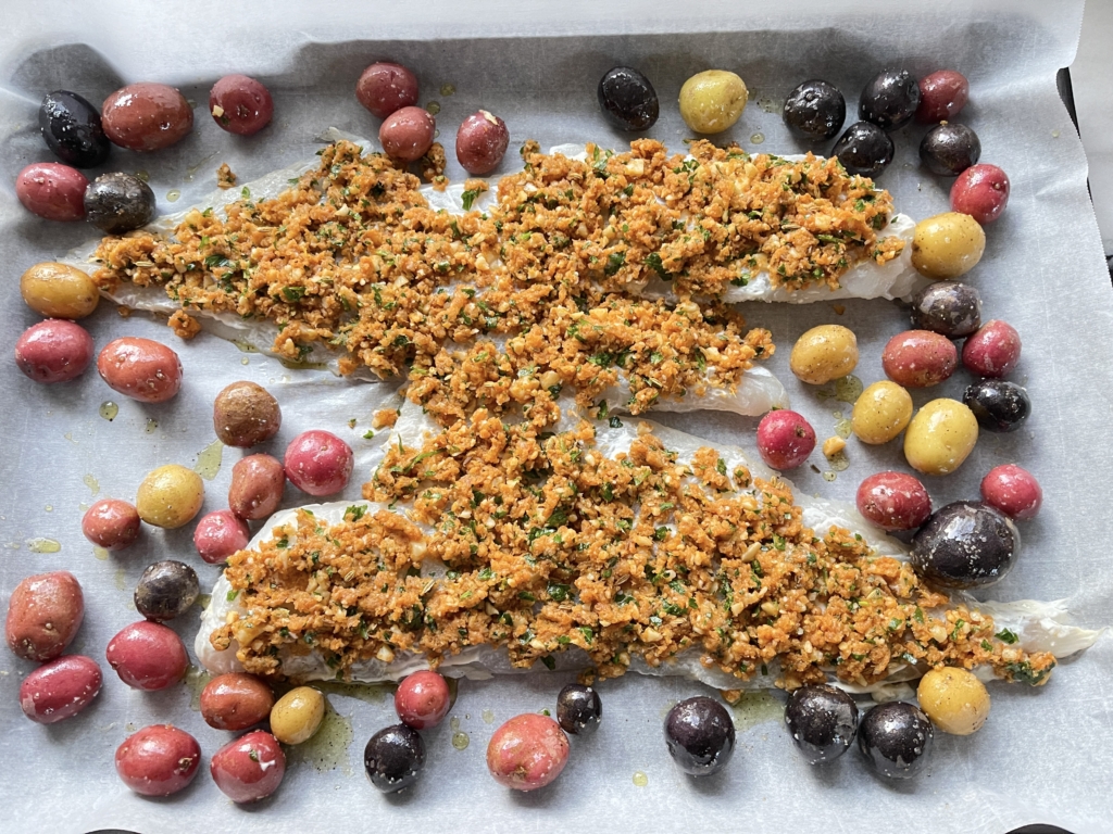 Then place potatoes on the sheet pan with the fish, pushing the potatoes to edges.