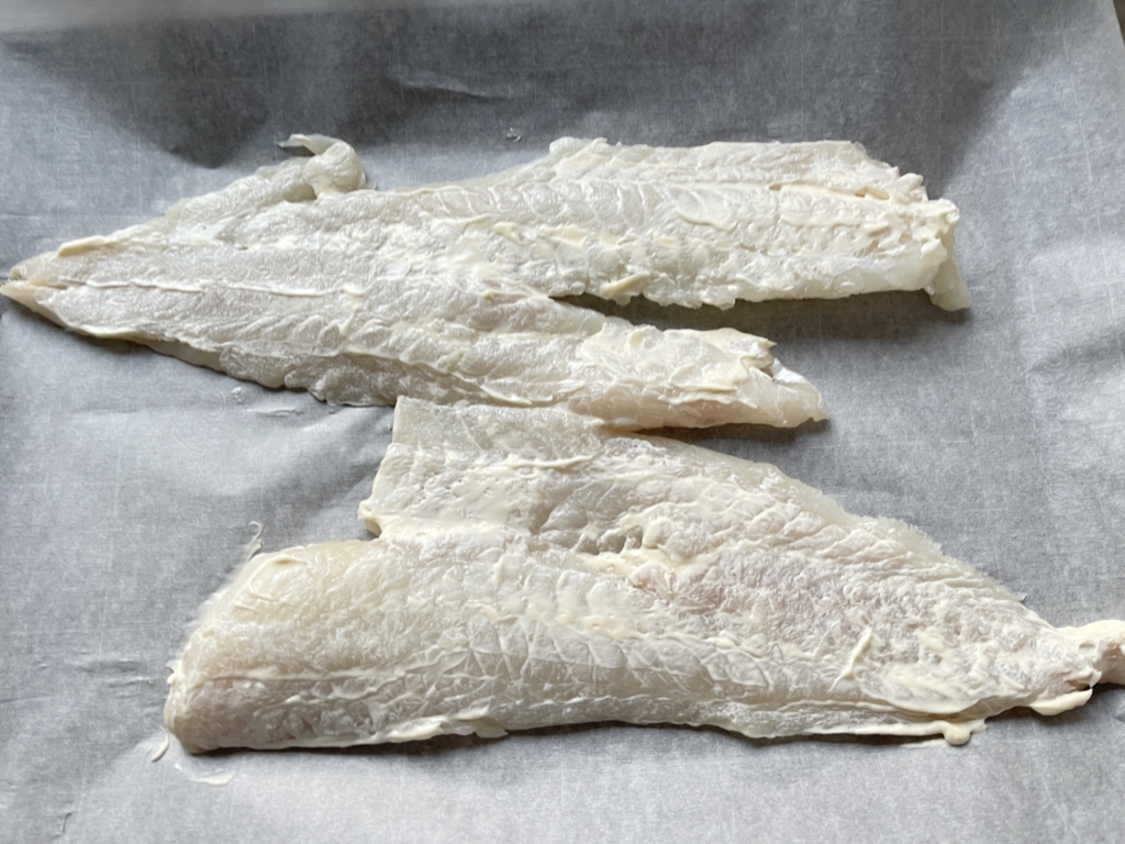 Pat fish fillet(s) dry and place in center of a parchment or foil lined baking sheet. Spread a thin layer of mayonnaise over fish.