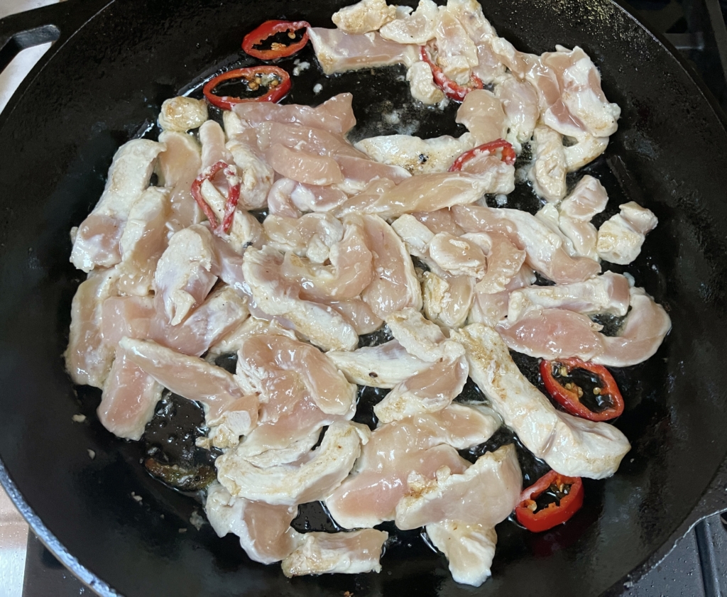 Then add the chicken to the pan and turn up the heat to high and cook chicken for approximately 2 minutes, mostly undisturbed. Chicken will not be cooked through.